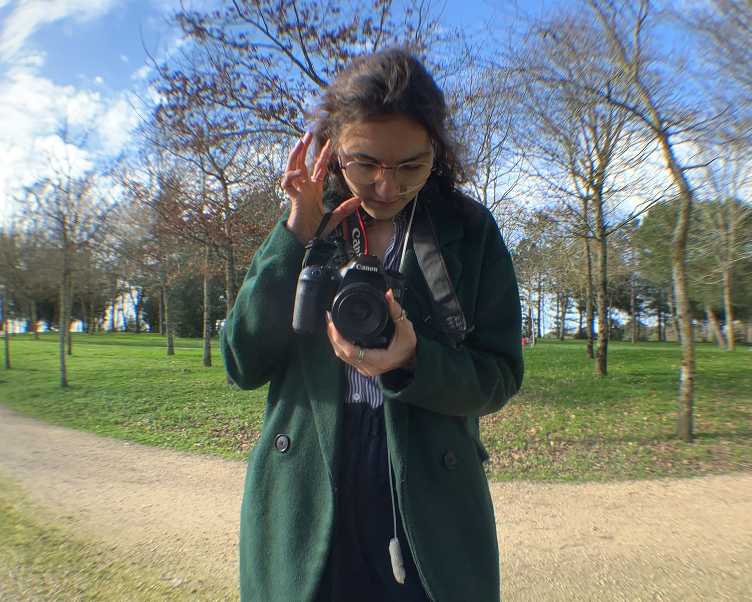 Maud Lenoir en prise de vue dans un parc, appareil photo en main